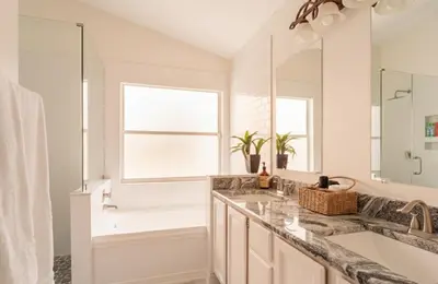 a white bathroom with a sink and a window at East Orlando Getaway - 3BR/2BTH - *Pool *Parking in Orlando
