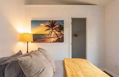 a living room with a couch and a picture of a beach at East Orlando Getaway - 3BR/2BTH - *Pool *Parking in Orlando