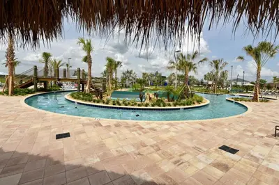 a circular pool with palm trees and a fountain at 4721 Unit 105 BRAND NEW stunning apartment in Kissimmee