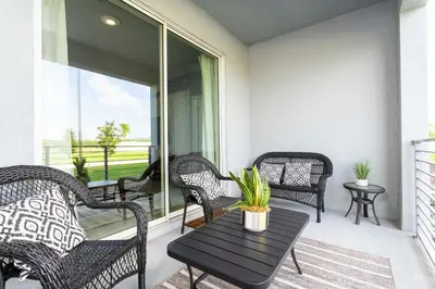 a porch with wicker chairs and a table with a plant at 4721 Unit 105 BRAND NEW stunning apartment in Kissimmee