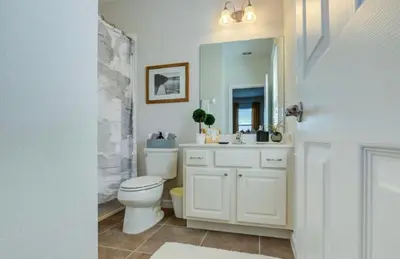 a bathroom with a toilet and a sink and a mirror at 6BR Resort Villa Near Disney Private Pool 2584 in Kissimmee