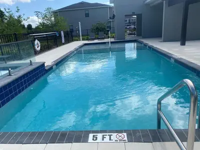 a large swimming pool with blue water at Relax water view with Hammock near Disney 4736 in Kissimmee
