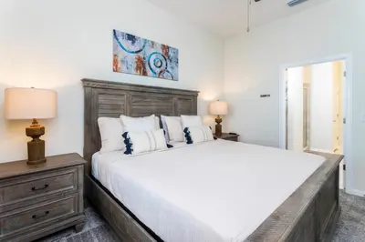 a bedroom with a large bed with a wooden headboard at Modern Condo with Lake View Near Disney 3151 in Kissimmee