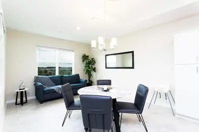 a living room with a table and a couch at Modern Condo with Lake View Near Disney 3151 in Kissimmee