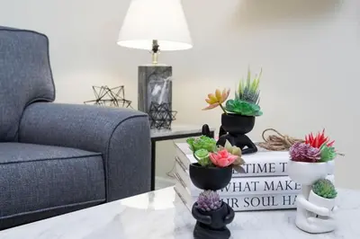 a living room with a couch and a table with potted plants at Modern Condo with Lake View Near Disney 3151 in Kissimmee