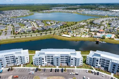 an aerial view of a large apartment complex next to a body of water at Modern Condo with Lake View Near Disney 3151 in Kissimmee