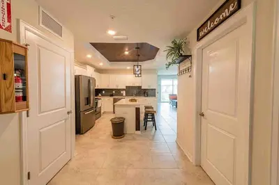 a kitchen with a white door and a kitchen with a counter at Resort Condo Near Disney FREE Waterpark 3120 in Kissimmee