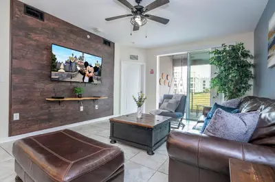 a living room with a couch and a tv on a wall at Resort Condo Near Disney FREE Waterpark 3120 in Kissimmee