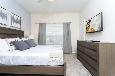 a bedroom with a large bed and a dresser at Special offer near Disney - free waterpark 2857 in Kissimmee