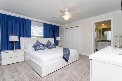 a bedroom with a white bed and blue curtains at Special offer near Disney - free waterpark 2857 in Kissimmee