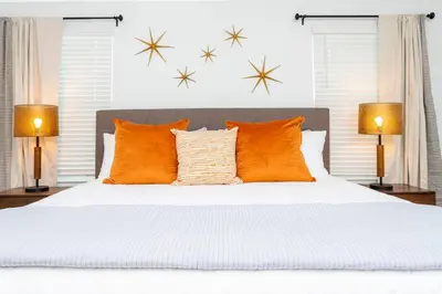 a bedroom with a large bed with orange pillows at free resort access, private pool near disney 2966 in Kissimmee