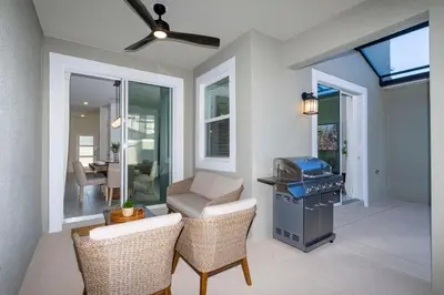 a kitchen with a grill and chairs and a living room at free resort access, private pool near disney 2966 in Kissimmee