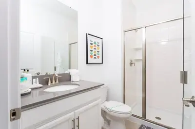 a white bathroom with a sink and a toilet at Modern Clean home Private Pool close Disney 2968 in Kissimmee