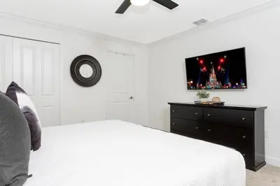 a bedroom with a bed and a tv on the wall at Modern Clean home Private Pool close Disney 2968 in Kissimmee