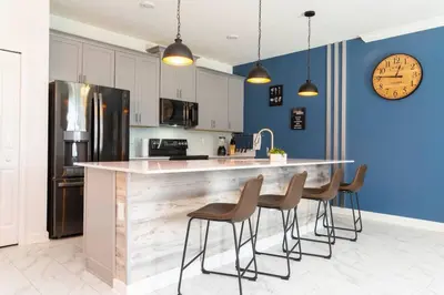 a kitchen with a counter with chairs and a counter top at FREE Waterpark 4BR Marvel Superhero-Themed 2967 in Kissimmee