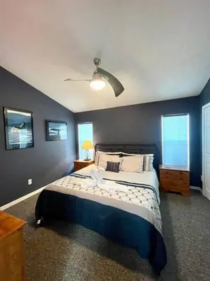 a bedroom with a large bed with a blue wall at Luxury Disney Family Villa (5-Bedroom, pool & spa) in Kissimmee