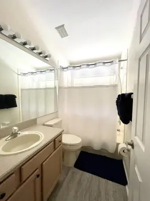 a white bathroom with a sink and a toilet at Luxury Disney Family Villa (5-Bedroom, pool & spa) in Kissimmee