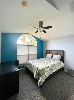 a bedroom with a bed and a ceiling fan at Luxury Disney Family Villa (5-Bedroom, pool & spa) in Kissimmee