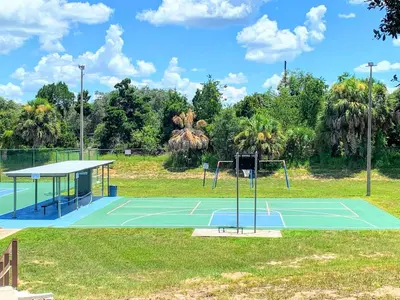 a tennis court in a park with trees at FUN! PoolLake near Disney Fast WiFi Pickleball in Clermont