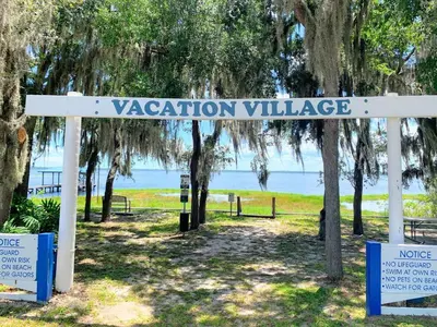 a sign that reads vacation village in a park at FUN! PoolLake near Disney Fast WiFi Pickleball in Clermont