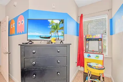 a bedroom with a black dresser with a television on it at Spacious 3BR Condo with Pool near Disney in Orlando