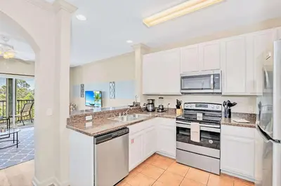 a kitchen with white cabinets and a stove top oven at Spacious 3BR Condo with Pool near Disney in Orlando