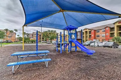 a playground with a blue slide and a blue canopy at very Nice 2/2 apartment , close to disney in Kissimmee