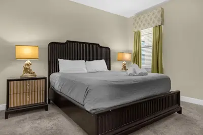 a bedroom with a large bed with two lamps at 7601-IBRAHIM · 7601 Themed 7BD Villa- Poolspa - Game room in Orlando