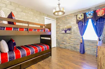 a bedroom with two bunk beds and a brick wall at 7601-IBRAHIM · 7601 Themed 7BD Villa- Poolspa - Game room in Orlando