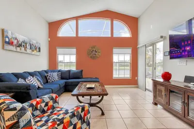 a living room with a blue couch and a table at Star Lake Oasis - 4 bed family pool home in Orlando