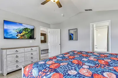 a bedroom with a bed and a flat screen tv at Star Lake Oasis - 4 bed family pool home in Orlando