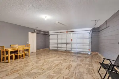 an empty room with a table and chairs and a room with a garage at South Facing Pool, Close to Attractions, Remodeled in Kissimmee