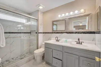 a bathroom with a toilet and a sink and a shower at South Facing Pool, Close to Attractions, Remodeled in Kissimmee