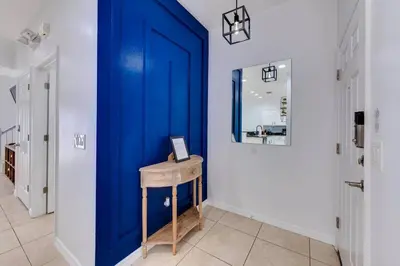 a blue door in a hallway with a wooden stool at Welcome to Villa Azul, your home away from home! in Kissimmee