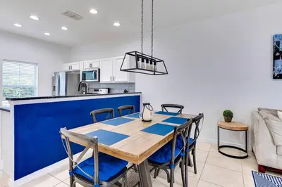 a kitchen and dining room with a wooden table and chairs at Welcome to Villa Azul, your home away from home! in Kissimmee