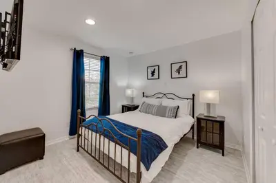 a white bedroom with a bed and a window at Welcome to Villa Azul, your home away from home! in Kissimmee
