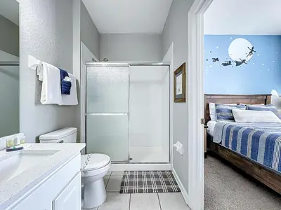 a bathroom with a shower and a toilet and a bed at Private Pool Disney Townhome - Walk to Water Park in Orlando