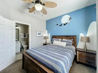 a bedroom with a bed with a blue wall at Private Pool Disney Townhome - Walk to Water Park in Orlando