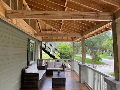 a porch with awning and chairs and a table at The Front Porch in Sanford