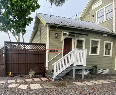 a green house with a white stair hesitate sign on it at Boho Nights in Sanford