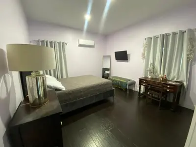 a bedroom with a bed and a desk and a lamp at Boho Nights in Sanford