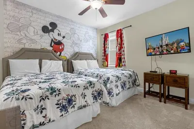a bedroom with two beds and a mickey mouse wallpaper at 431 Villa - Spacious 7BD - Screened PoolSPA in Orlando