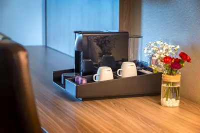 a room with a tv and a vase of flowers at Pestana Orlando Suites - Lake Buena Vista in Orlando