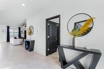 a living room with a console table and a mirror at Disney Dream Vacation Home by Disney in Kissimmee