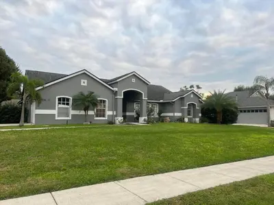 a house with a green lawn in front of it at Dreamy Family Pool House in Clermont