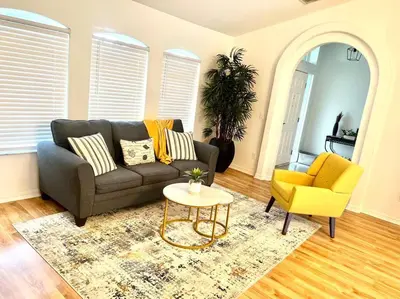 a living room with a couch and a yellow chair at Dreamy Family Pool House in Clermont
