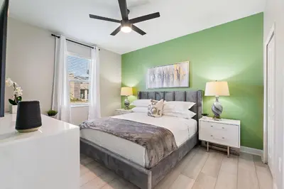 a bedroom with a bed and a green wall at Water Kingdom Storey Lake By Shine Villas #525 in Kissimmee