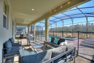 a glassconservatory with couches and chairs on a patio at Water Kingdom Storey Lake By Shine Villas #525 in Kissimmee