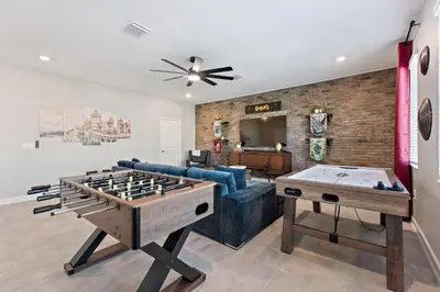 a living room with a couch and a ping pong table at Water Kingdom Storey Lake By Shine Villas #525 in Kissimmee