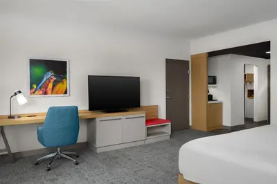 a room with a desk with a television and a bed at Hilton Garden Inn Orlando I-4 Millenia Blvd Mall in Orlando